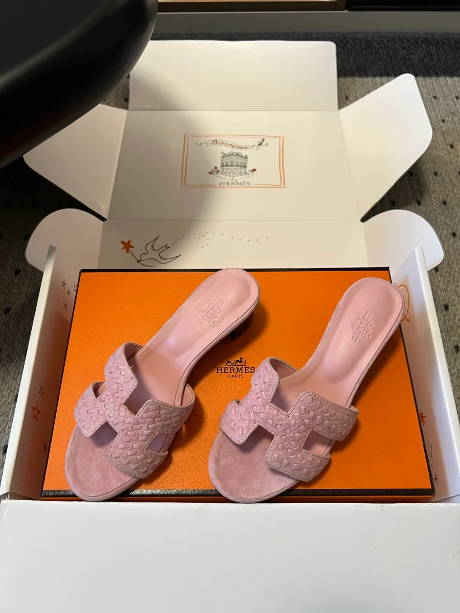 Вид сбоку на розовые плетёные шлёпанцы Hermes