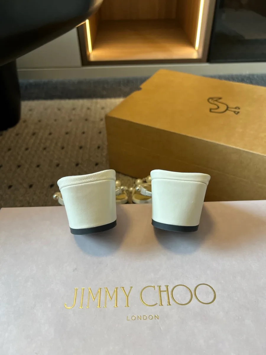 Устойчивые блочные каблуки белых босоножек с логотипом Jimmy Choo на коробке