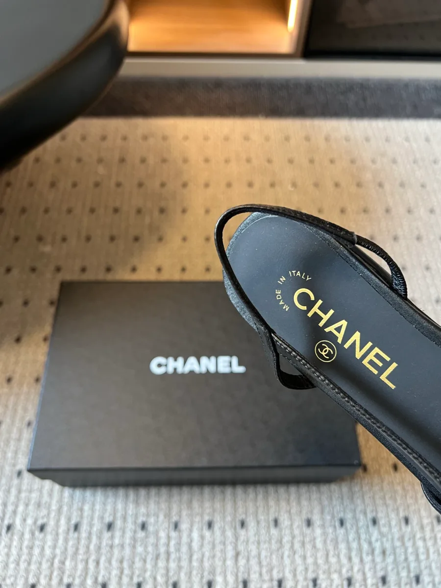 Деталь кожаной стельки чёрного цвета с золотистым логотипом Chanel