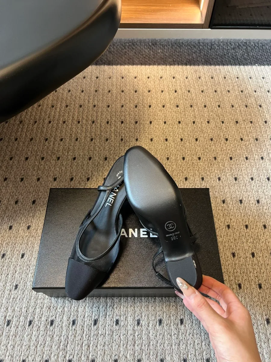 Чёрная туфля Chanel, демонстрация кожаной подошвы и каблука