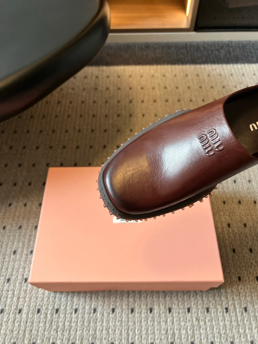 Закруглённый мыс коричневого сабо с тиснёным логотипом Miu Miu