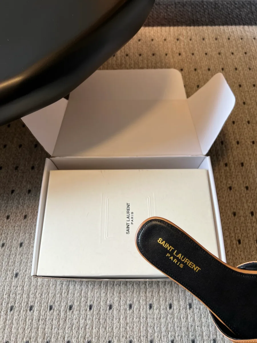 Крупный план стельки шлепанца с золотистым тиснением Saint Laurent Paris