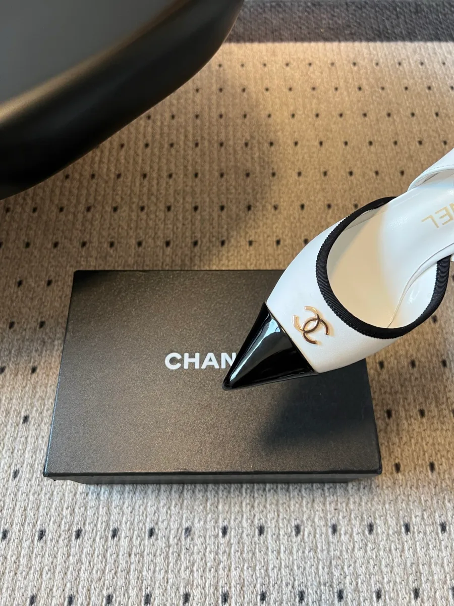 Заострённый чёрный мыс и золотистый логотип CC слингбэков Chanel крупным планом