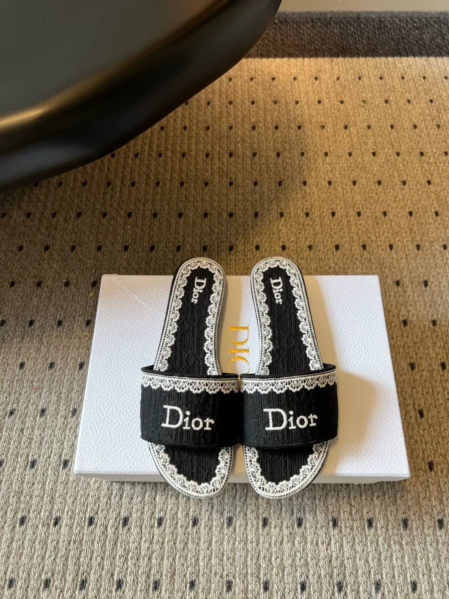 Чёрные текстильные шлёпанцы с вышивкой Dior и кружевом, вид сверху на коробке
