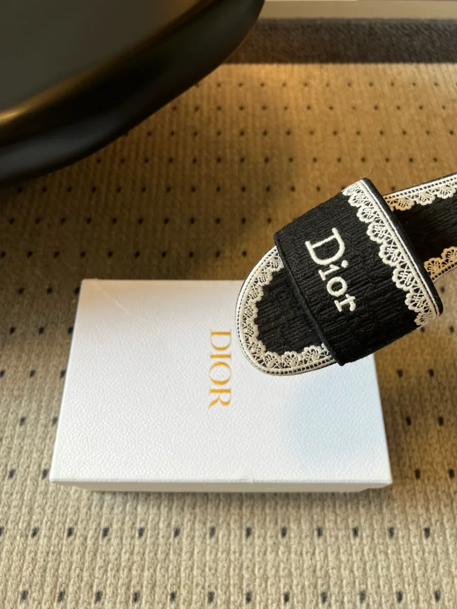 Широкая перемычка шлёпанца с белой вышивкой Dior и кружевной отделкой, крупный план