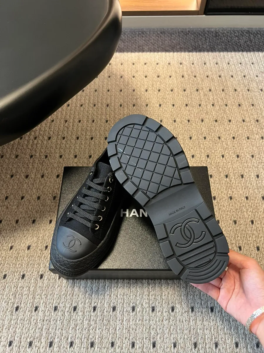 Чёрные кеды Chanel, демонстрация рельефной подошвы с логотипом CC