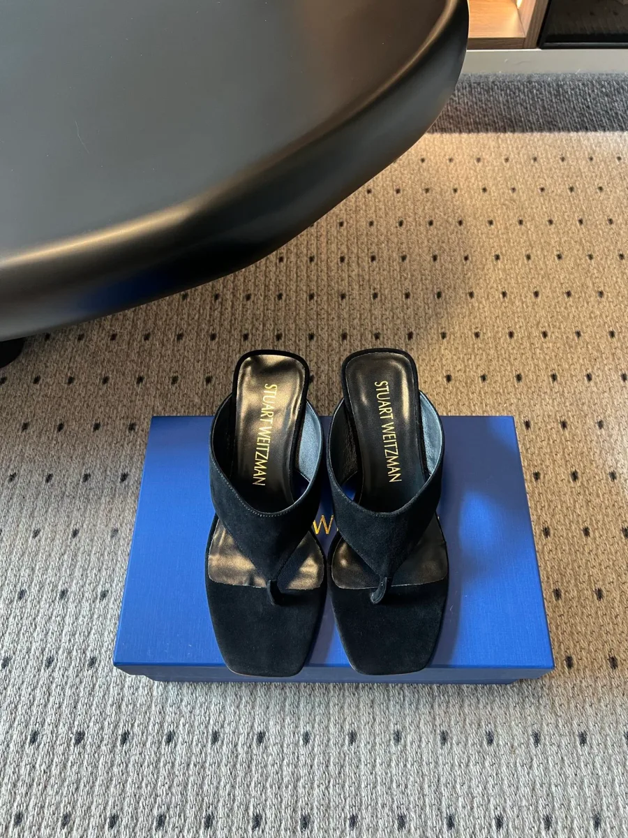 Чёрные замшевые шлепанцы Stuart Weitzman с открытым носком на синей коробке, вид сверху