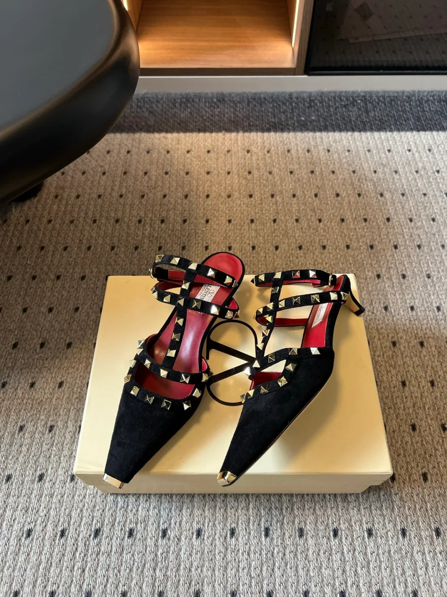 Пара чёрных туфель с шипами Rockstud на фирменной коробке