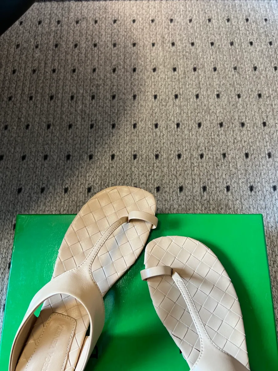 Передняя часть пары бежевых шлепанцев с плетёной фактурой стельки