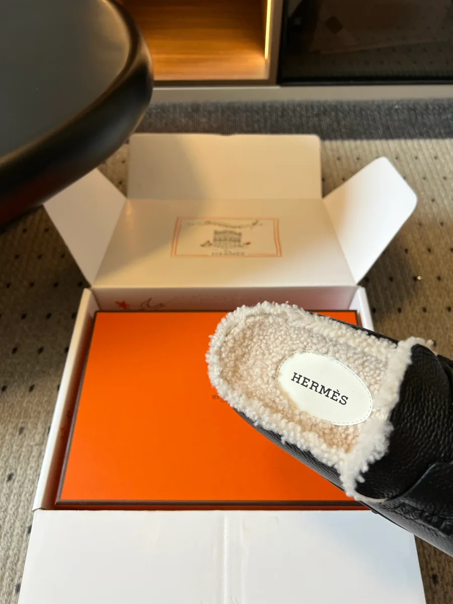 Стелька мюли из светлой овчины с кожаной нашивкой Hermes крупным планом