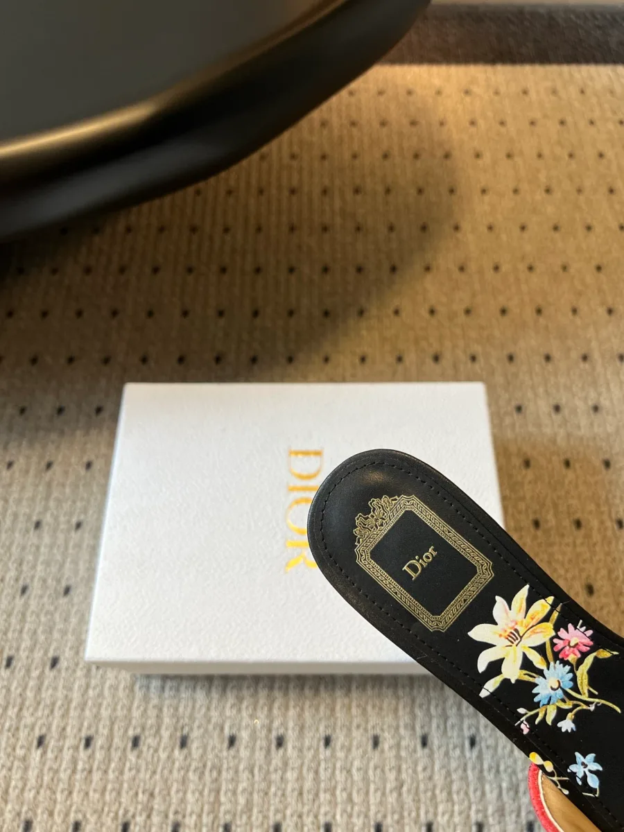 Деталь кожаной стельки шлёпанца Dior с цветочным рисунком и логотипом на пятке
