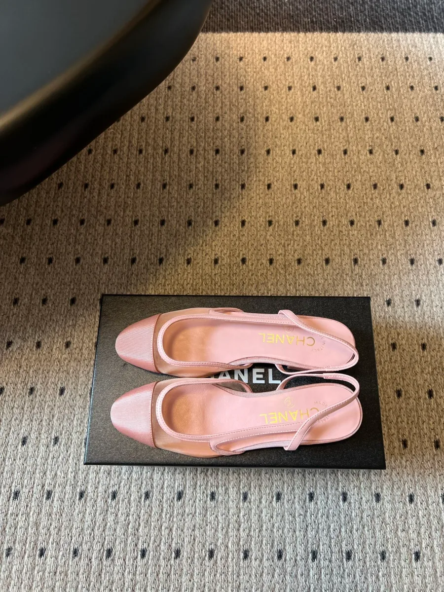 Розовые слингбэки Chanel на черной коробке, вид сверху на стельки с логотипом