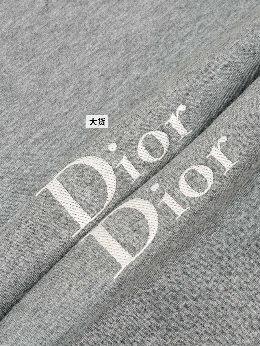 Крупный план рельефной вышивки логотипа Dior светлыми нитями