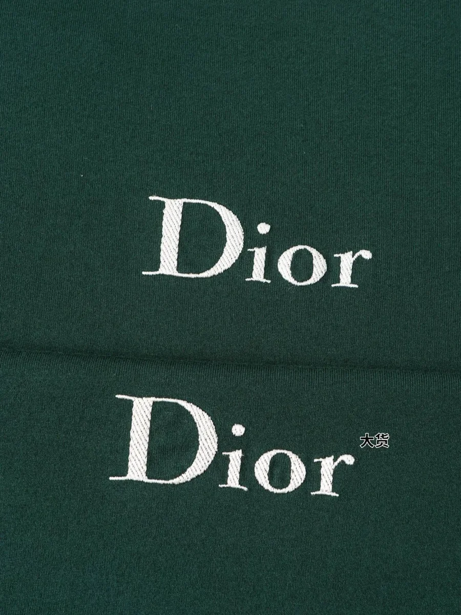 Белая вышивка логотипа Dior на зелёном хлопковом полотне крупным планом