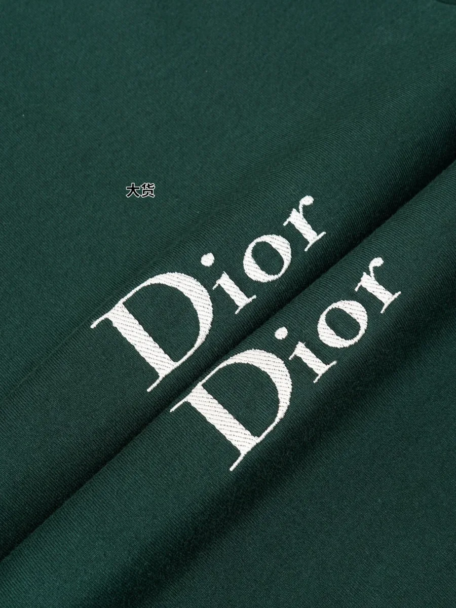 Вышитая надпись Dior на зелёной ткани в макросъёмке