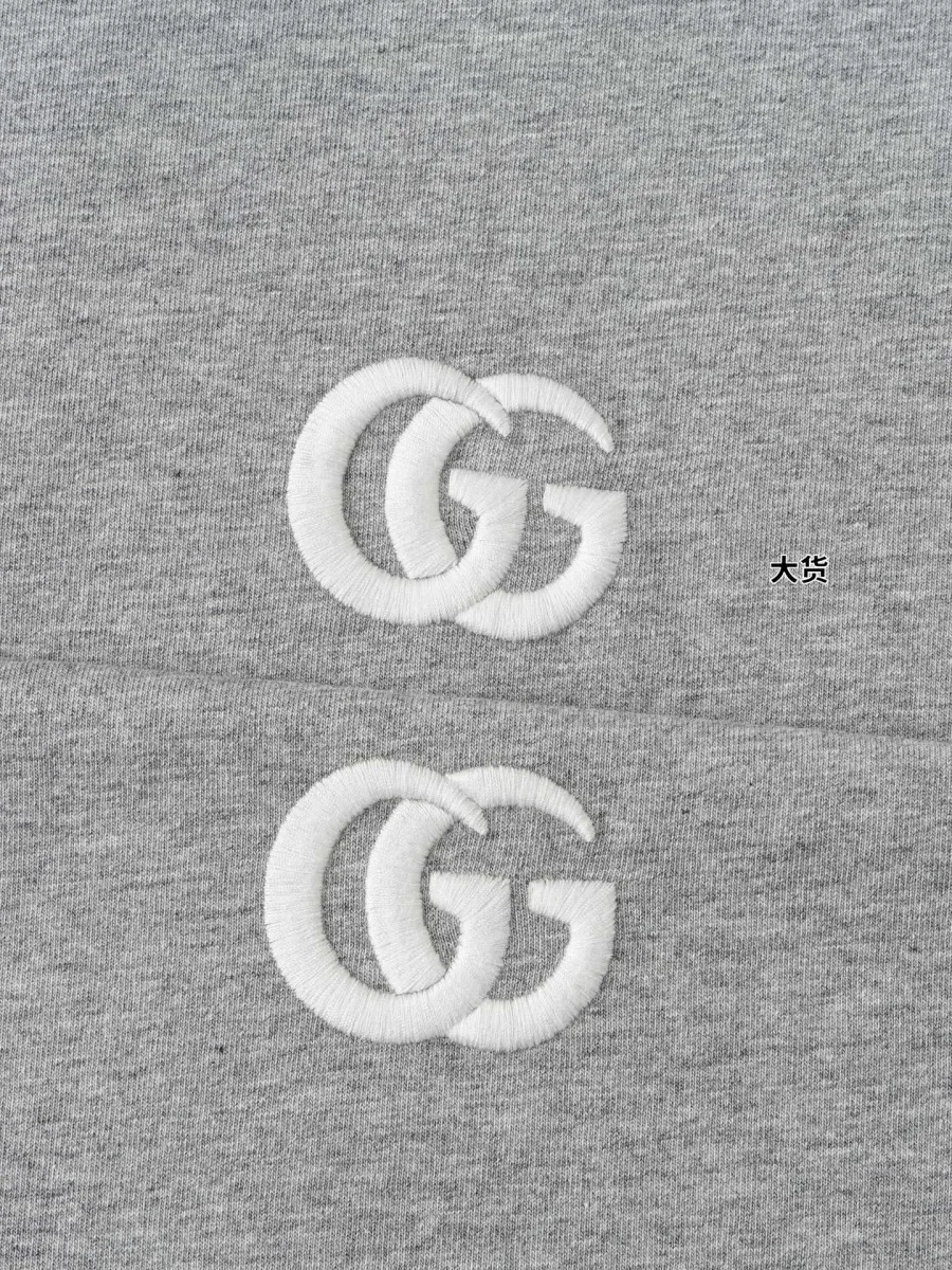 Рельефная белая вышивка логотипа Double G на сером трикотаже, макросъёмка