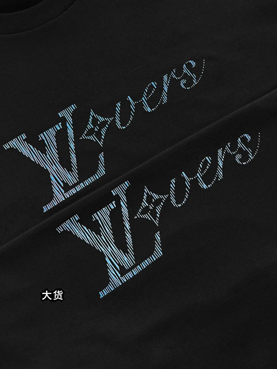 Крупный план вышитой надписи LV Lovers на груди чёрной футболки