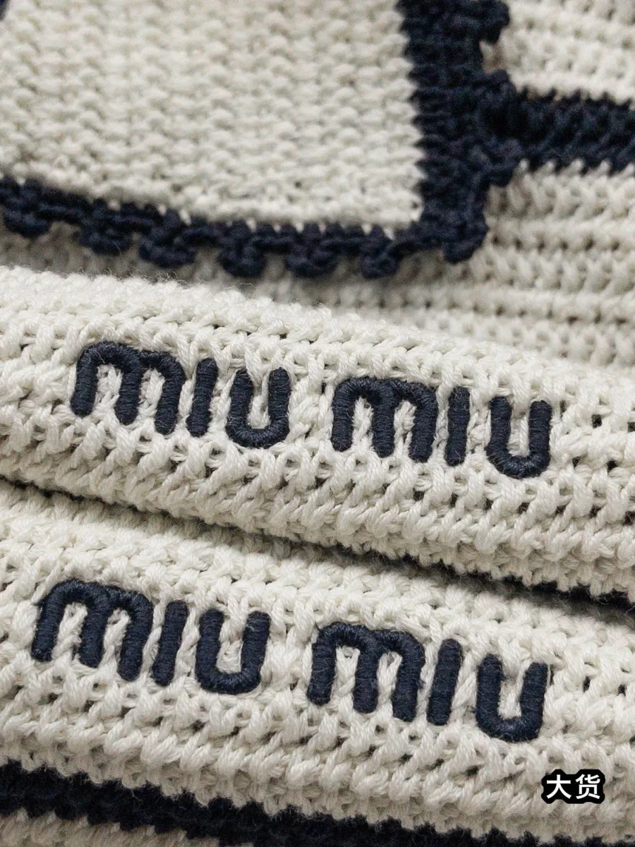 Крупный план объемной рельефной вышивки логотипа Miu Miu на груди