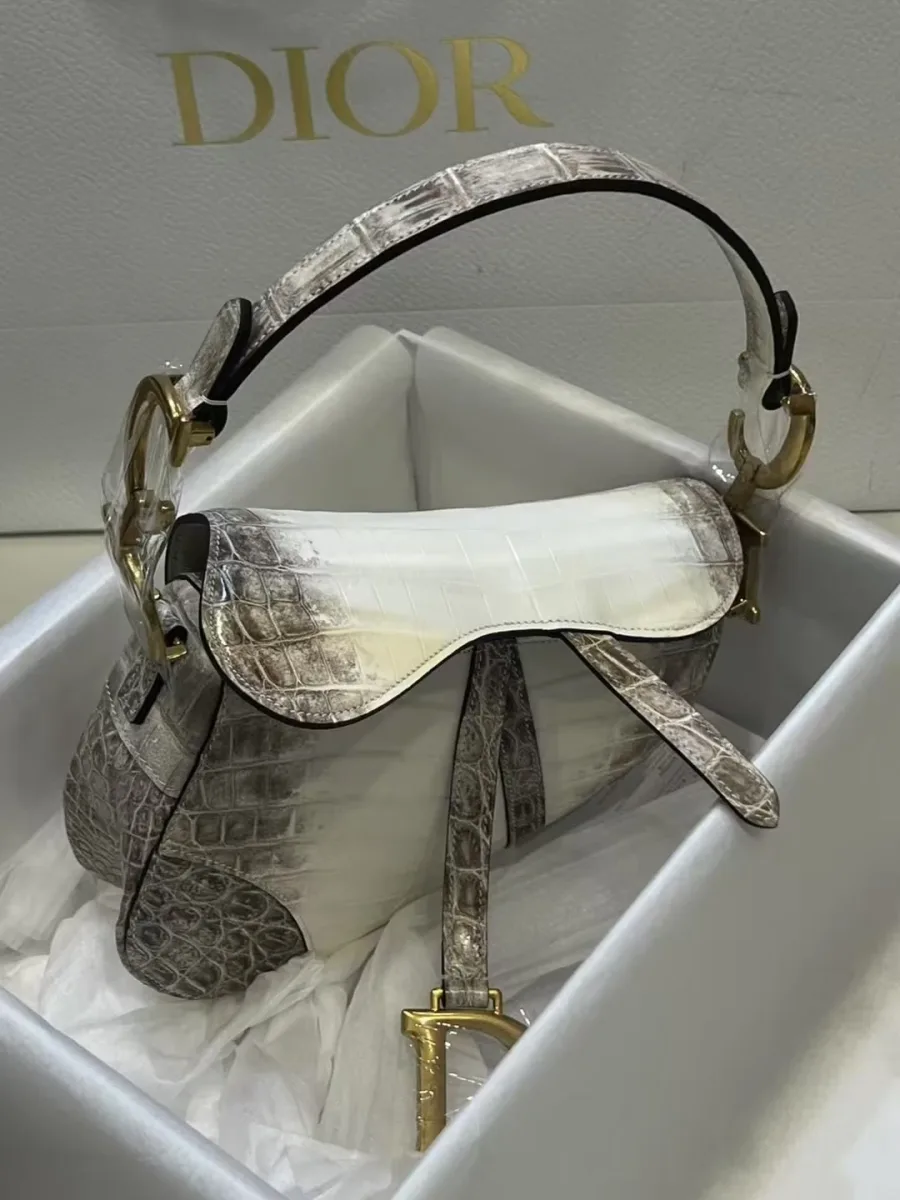 Сумка Saddle из кожи крокодила, ракурс три четверти с подвеской D