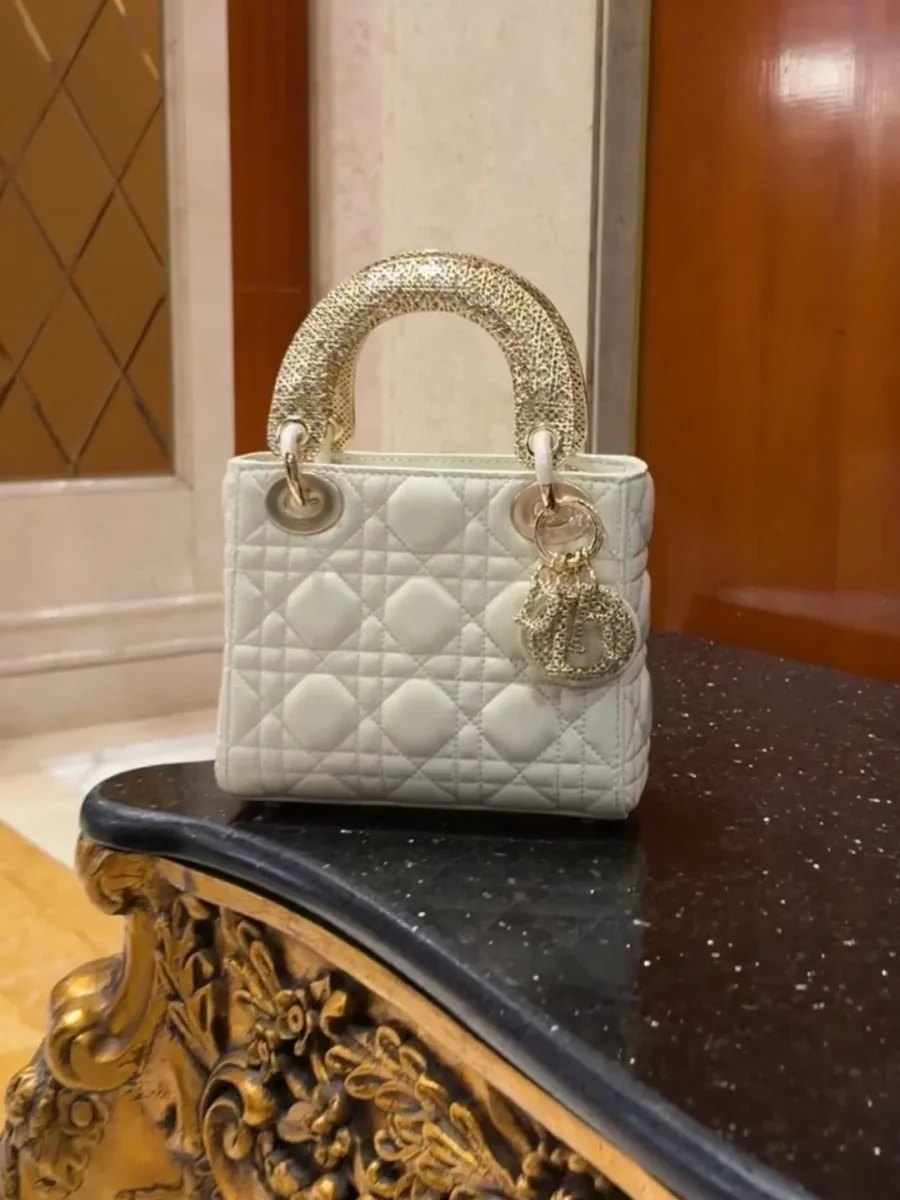 Стеганая сумка Lady Dior на темной полированной поверхности стола