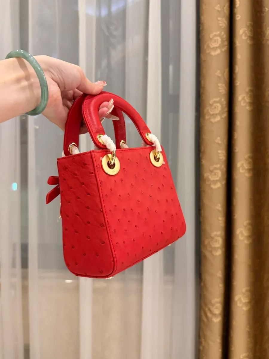 Боковая сторона красной сумки Lady Dior с плотными ручками
