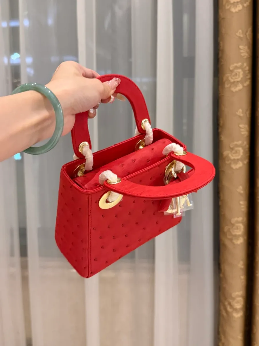 Верхняя часть красной сумки Lady Dior с закругленными ручками и подвесками