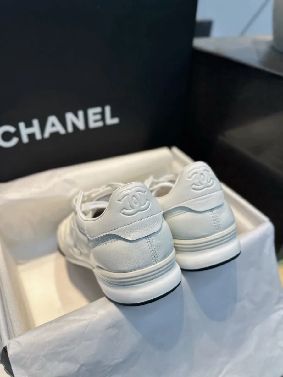 Задняя часть белых кроссовок Chanel с тиснёным логотипом CC на пятке