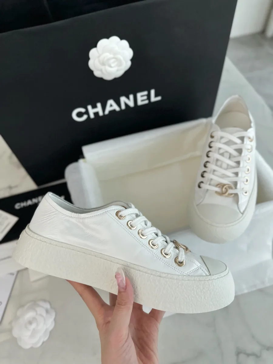 Белый кожаный кед Chanel на толстой подошве крупным планом сбоку