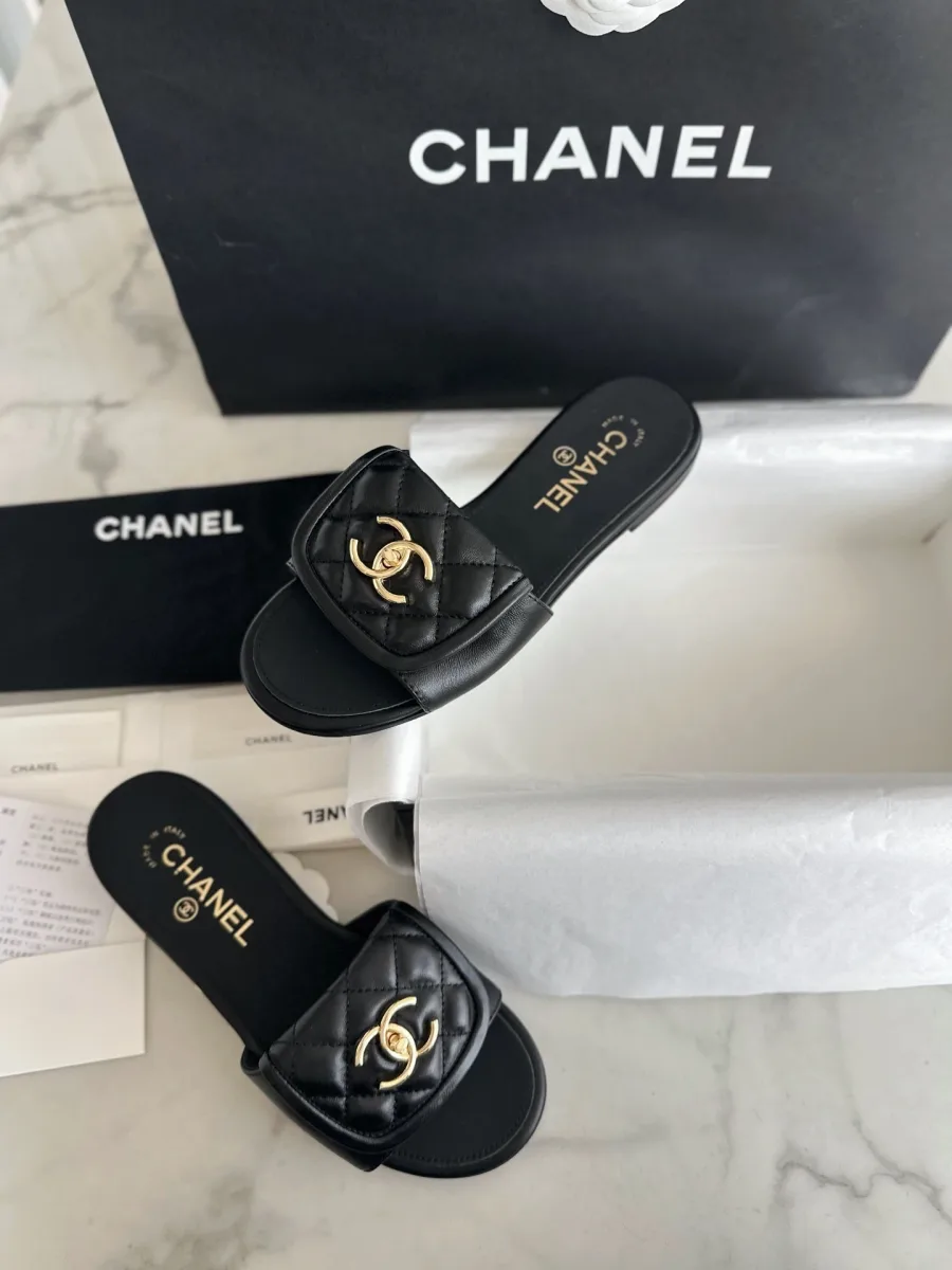 Женские шлёпанцы Chanel из чёрной кожи с логотипом CC, вид сверху на столе