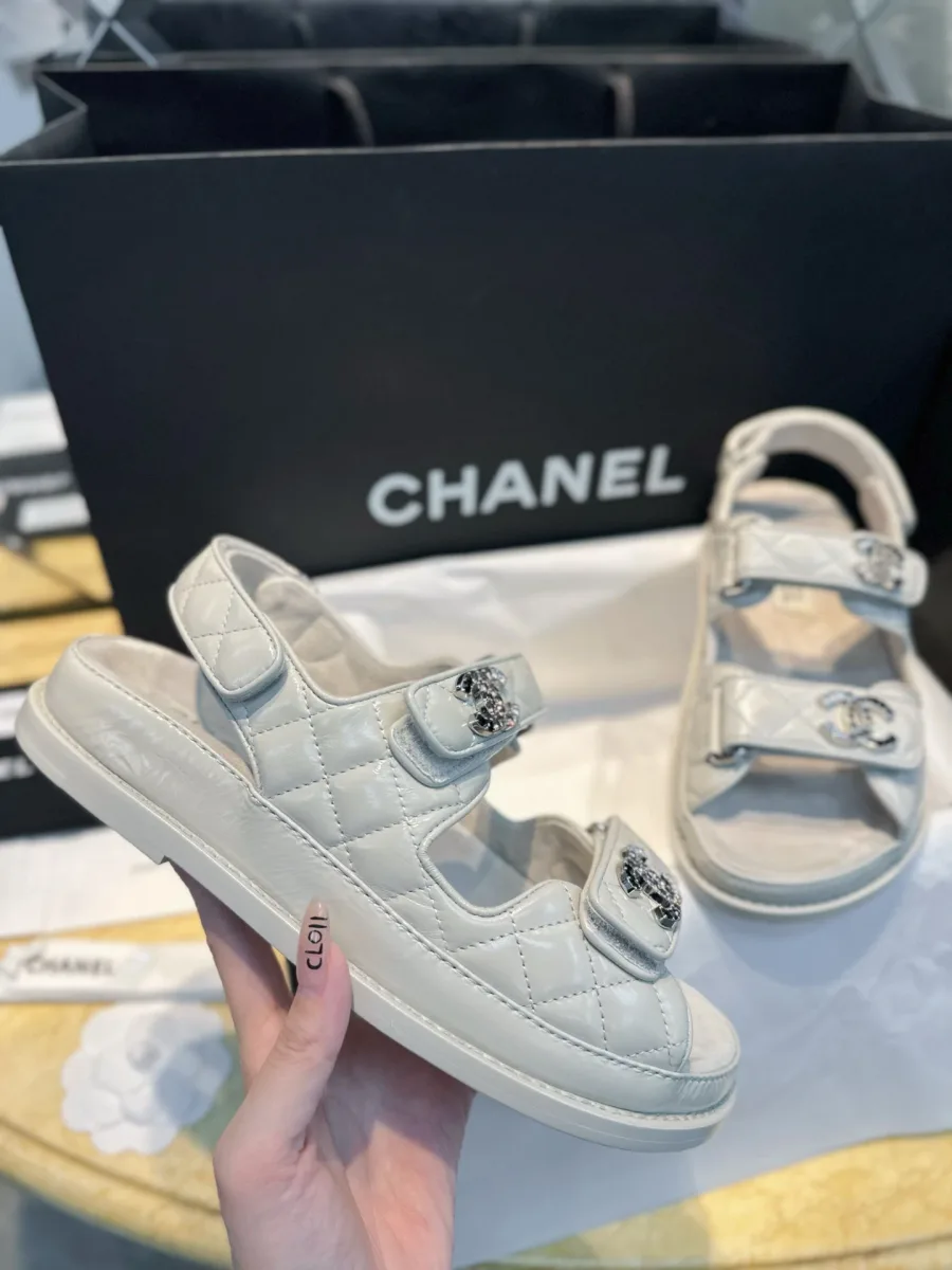 Белая сандалия Chanel на массивной подошве в руке
