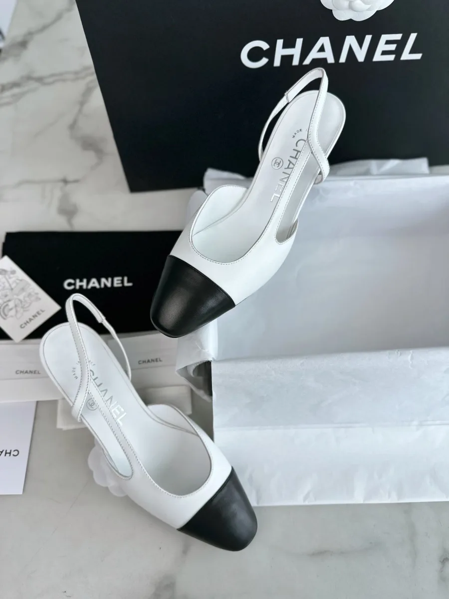 Бело-чёрные кожаные слингбэки Chanel, вид сверху на фоне коробки