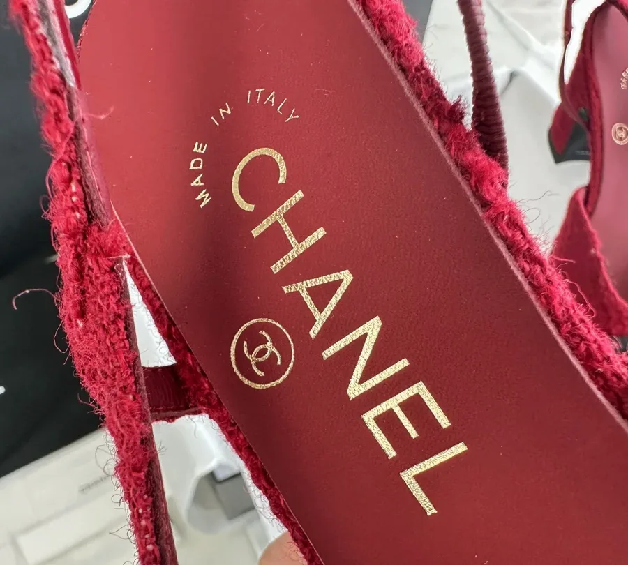 Крупный план кожаной стельки бордового цвета с золотистым логотипом Chanel