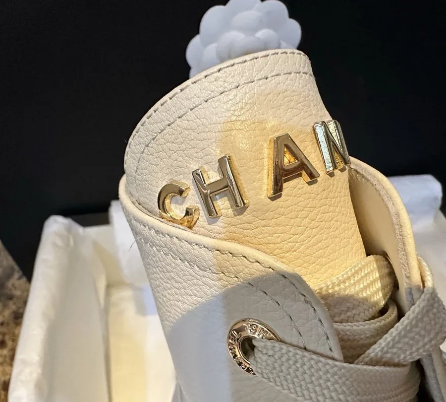 Язычок ботинка с золотистой объёмной надписью CHANEL