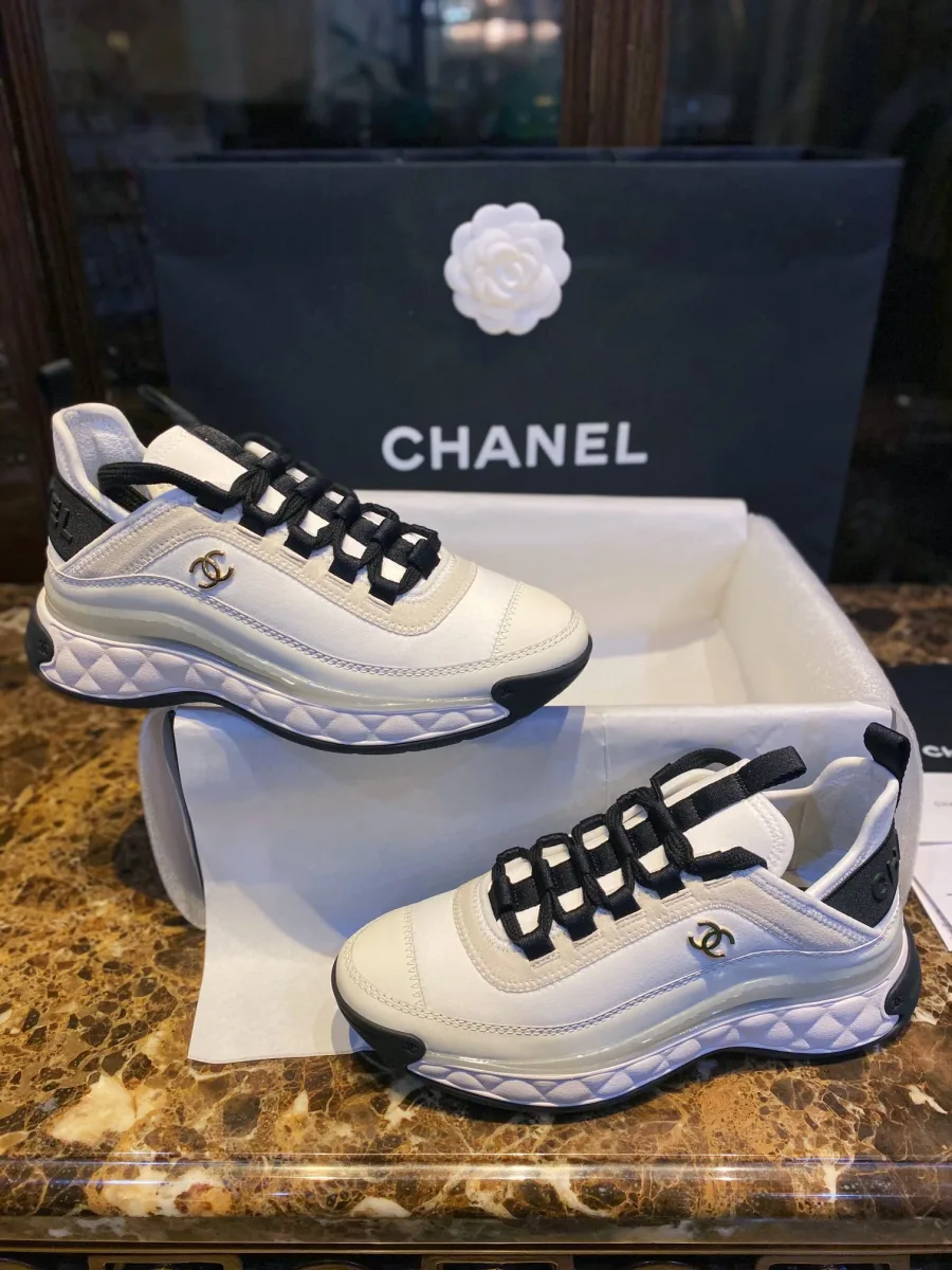 Пара кроссовок Chanel на подставке, вид сбоку на фигурную подошву