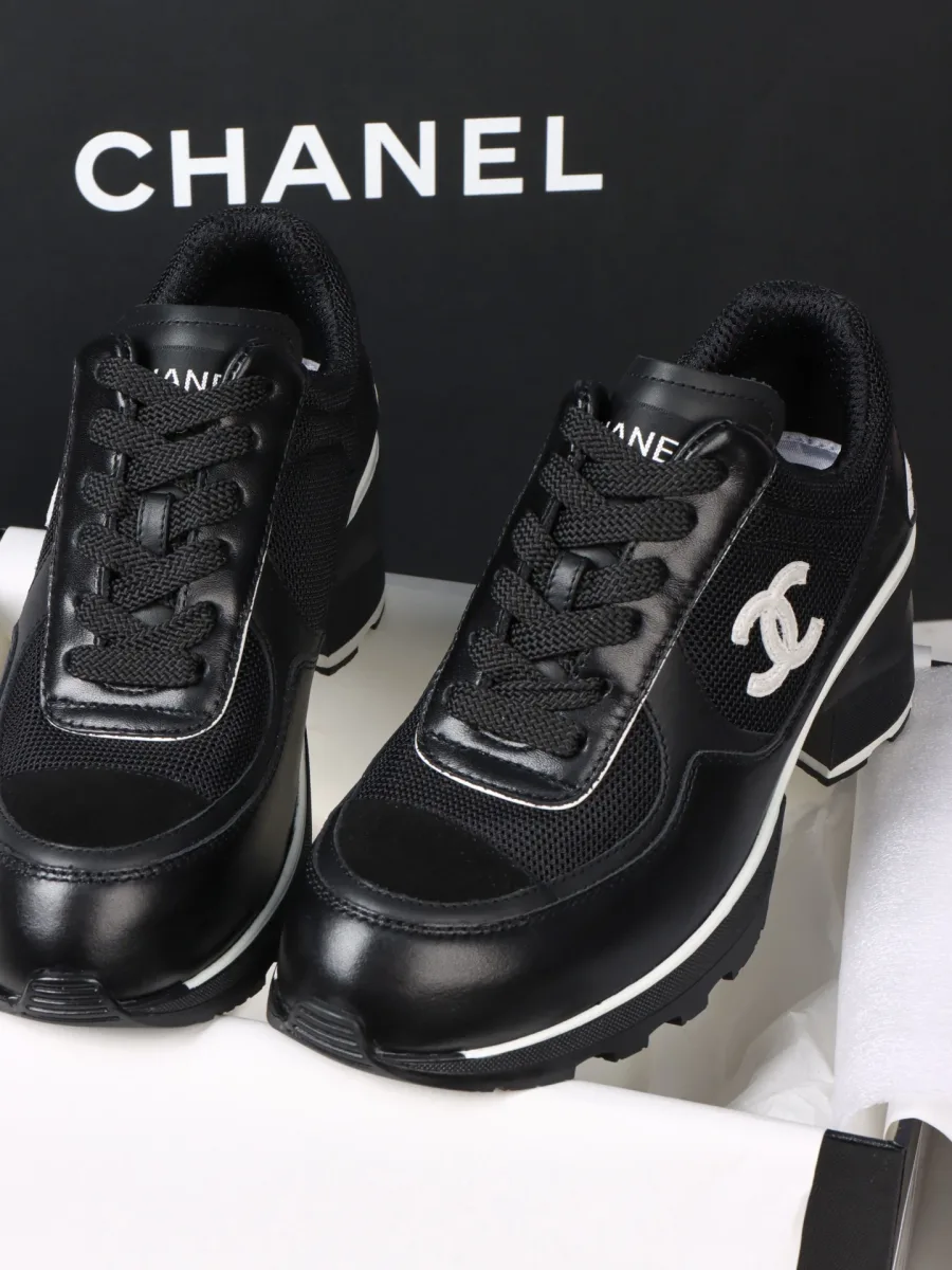 Пара чёрных кроссовок Chanel на массивном каблуке, ракурс три четверти спереди