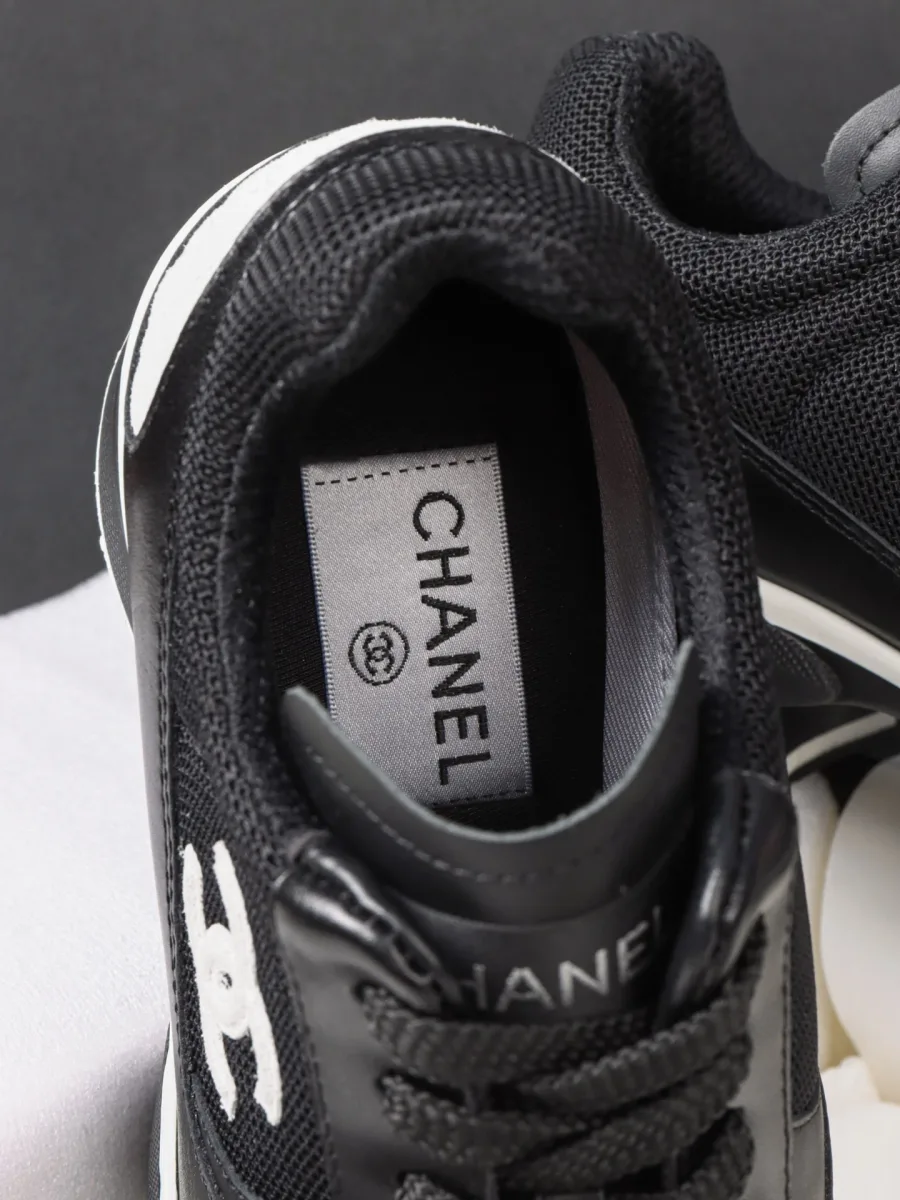 Внутренняя часть чёрного кроссовка Chanel с кожаной стелькой и логотипом