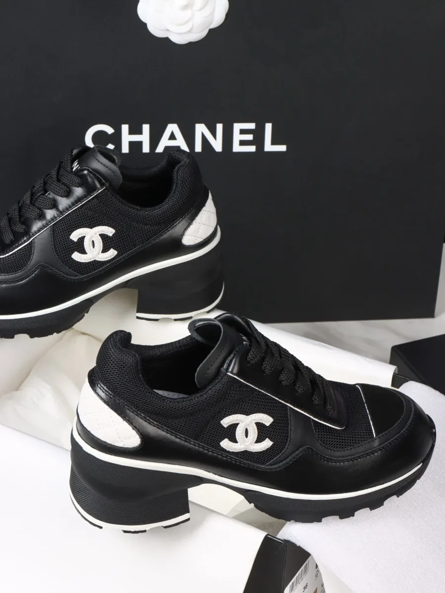 Пара чёрных женских кроссовок Chanel на массивной подошве, вид сбоку