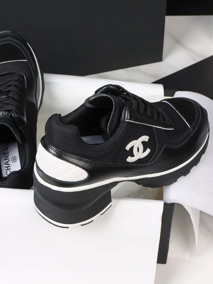 Чёрный кроссовок Chanel с белым логотипом CC и массивным каблуком, вид сбоку