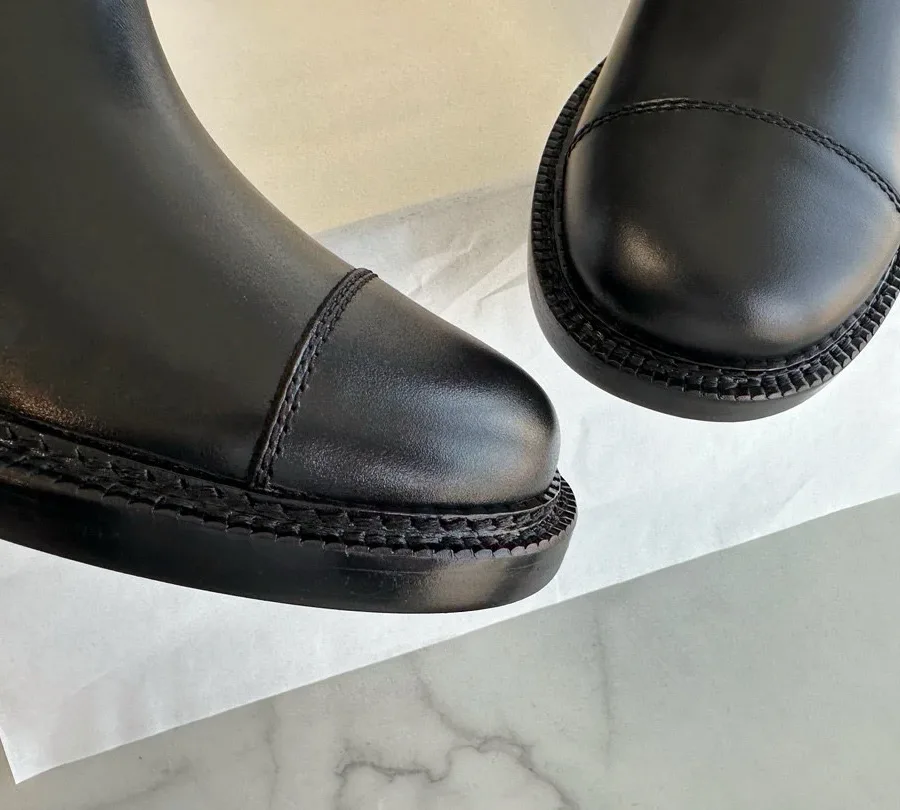 Крупный план закруглённого отрезного мыска сапог Chanel со строчкой