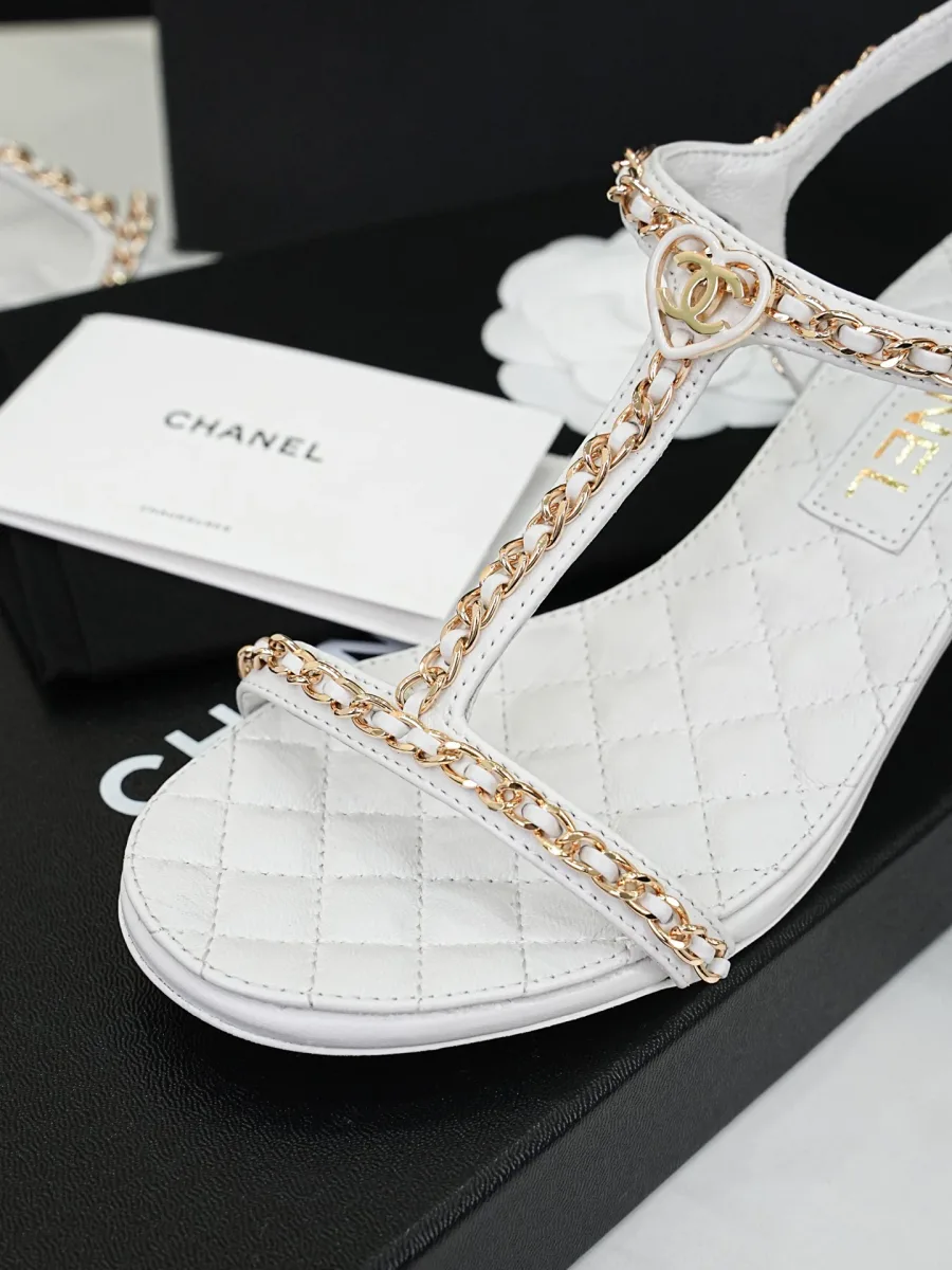 Мысок белой босоножки Chanel с декором в виде сердца CC на цепочке, крупный план