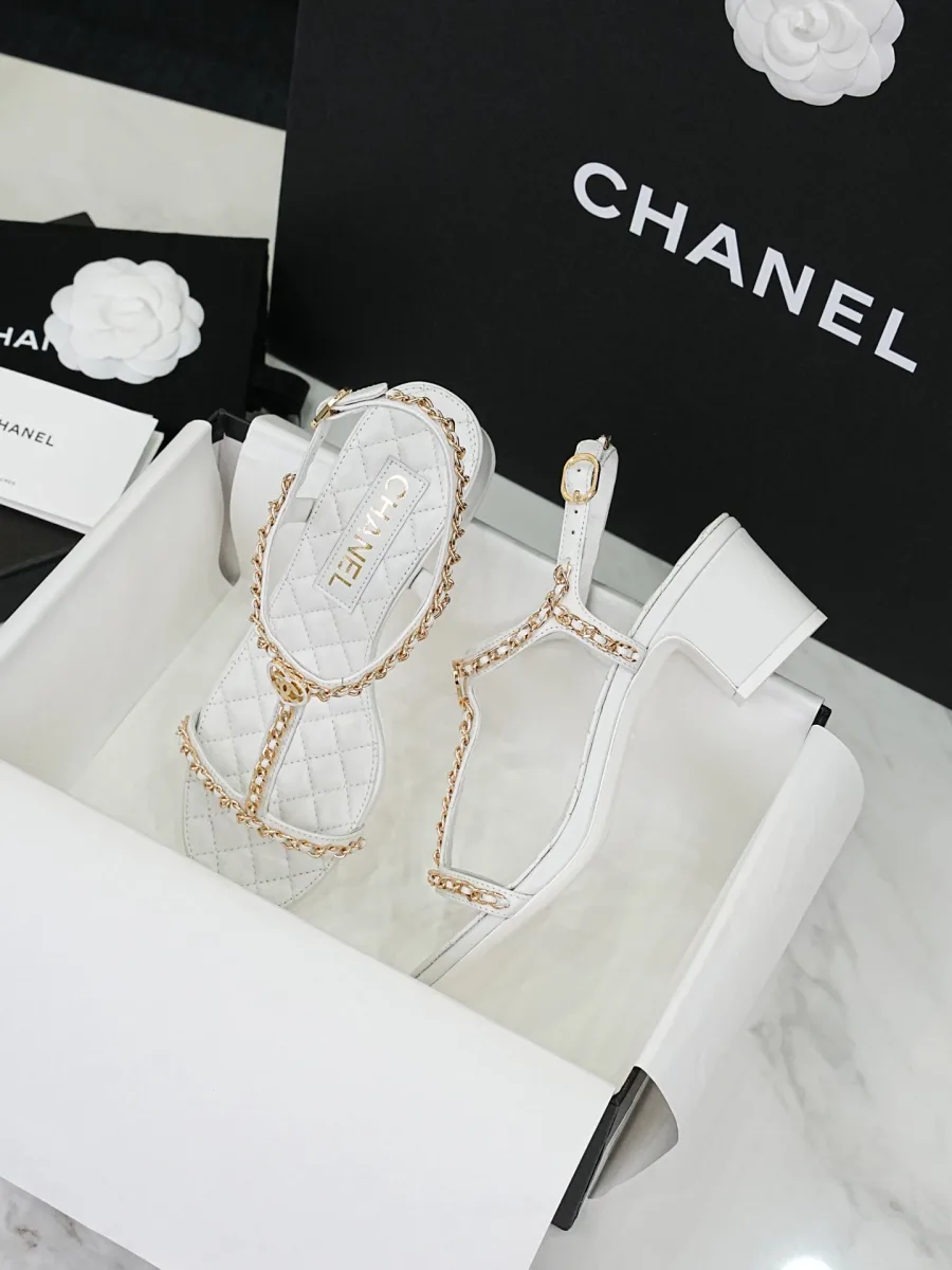 Пара белых босоножек Chanel со стеганой стелькой в коробке, ракурс три четверти