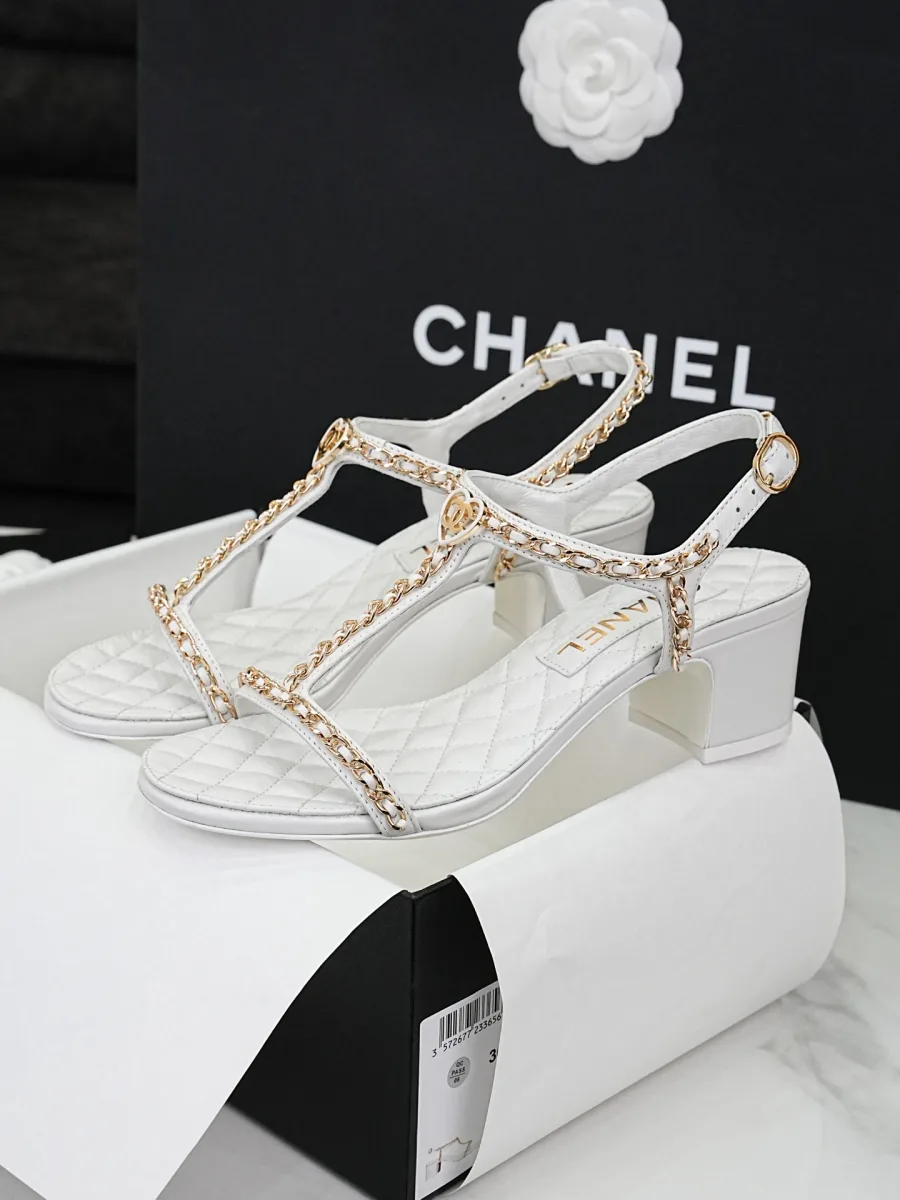 Белые босоножки Chanel с цепочками и декоративным логотипом, ракурс сбоку
