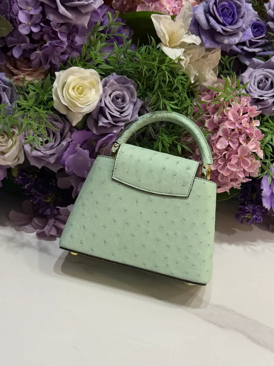 Задняя сторона светло-зелёной сумки из фактурной кожи страуса