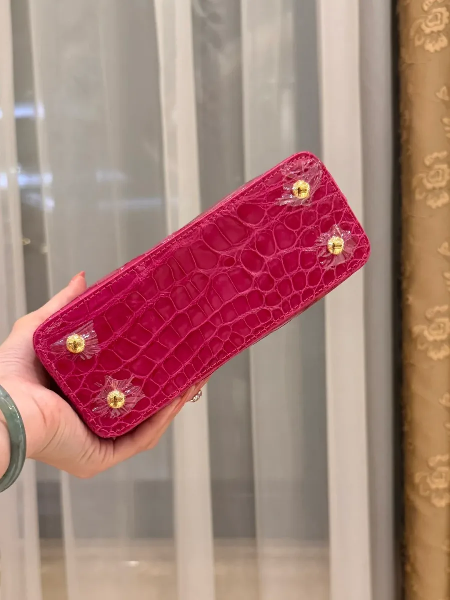 Нижняя часть розовой сумки Capucines BB с защитными ножками на дне