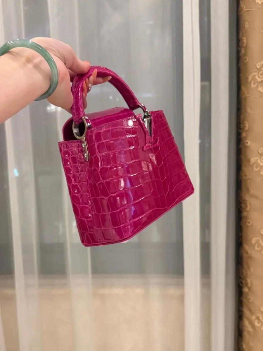 Розовая сумка Capucines BB из фактурной кожи крокодила, вид в три четверти