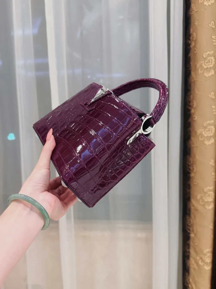 Боковая и нижняя часть фиолетовой сумки из кожи крокодила