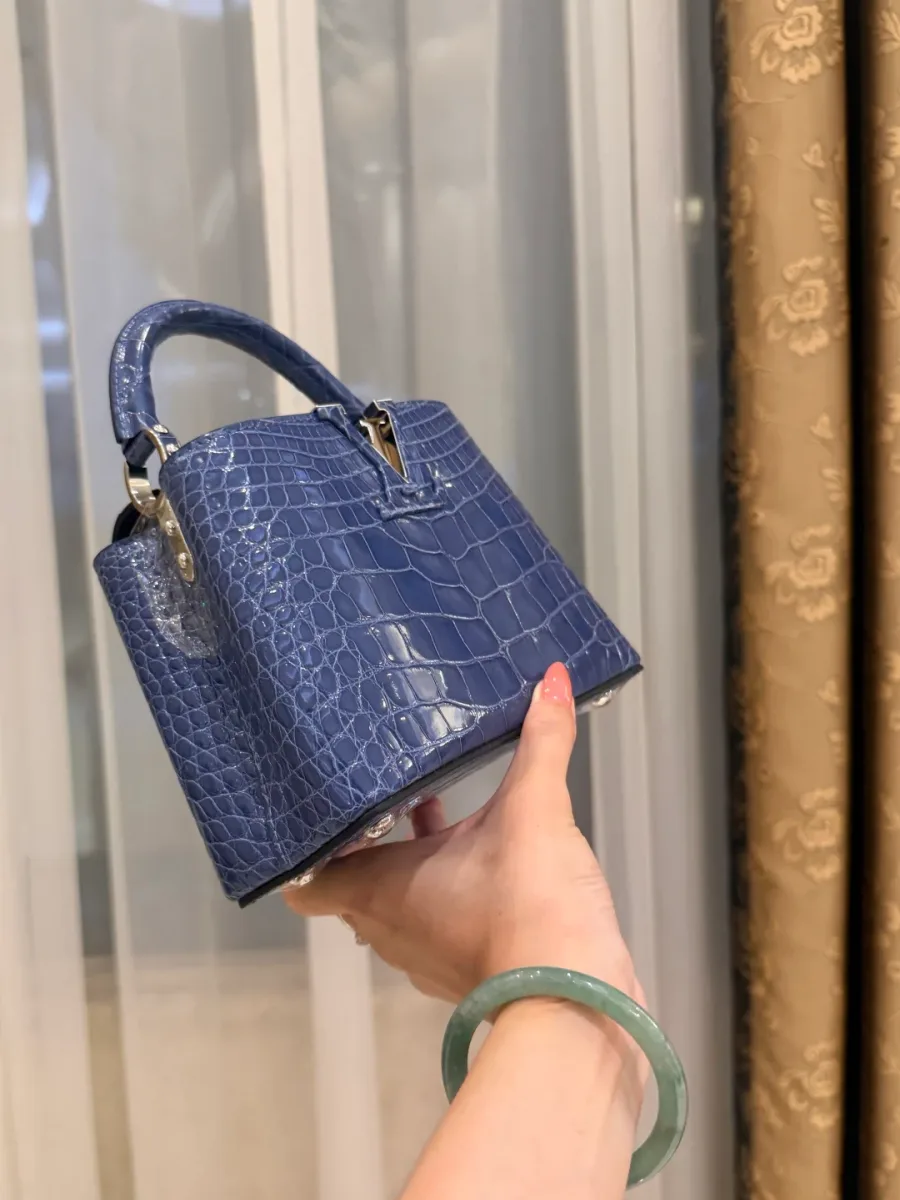 Синяя сумка Capucines BB из кожи крокодила, ракурс в три четверти