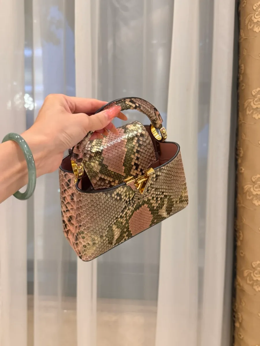 Розовая сумка Capucines из кожи змеи, ракурс сверху с заправленным клапаном