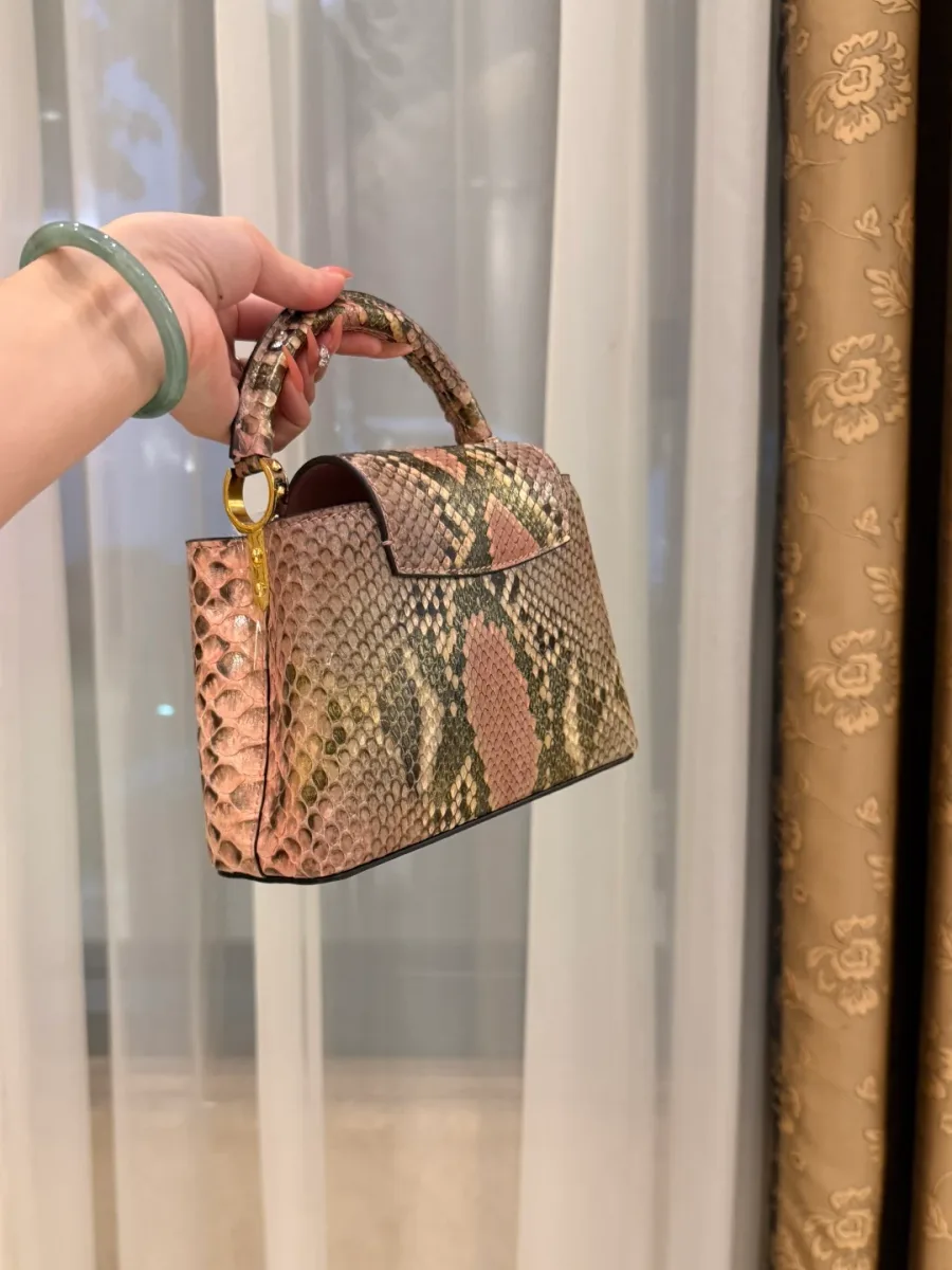 Розовая сумка Capucines из кожи змеи, ракурс три четверти со стороны клапана