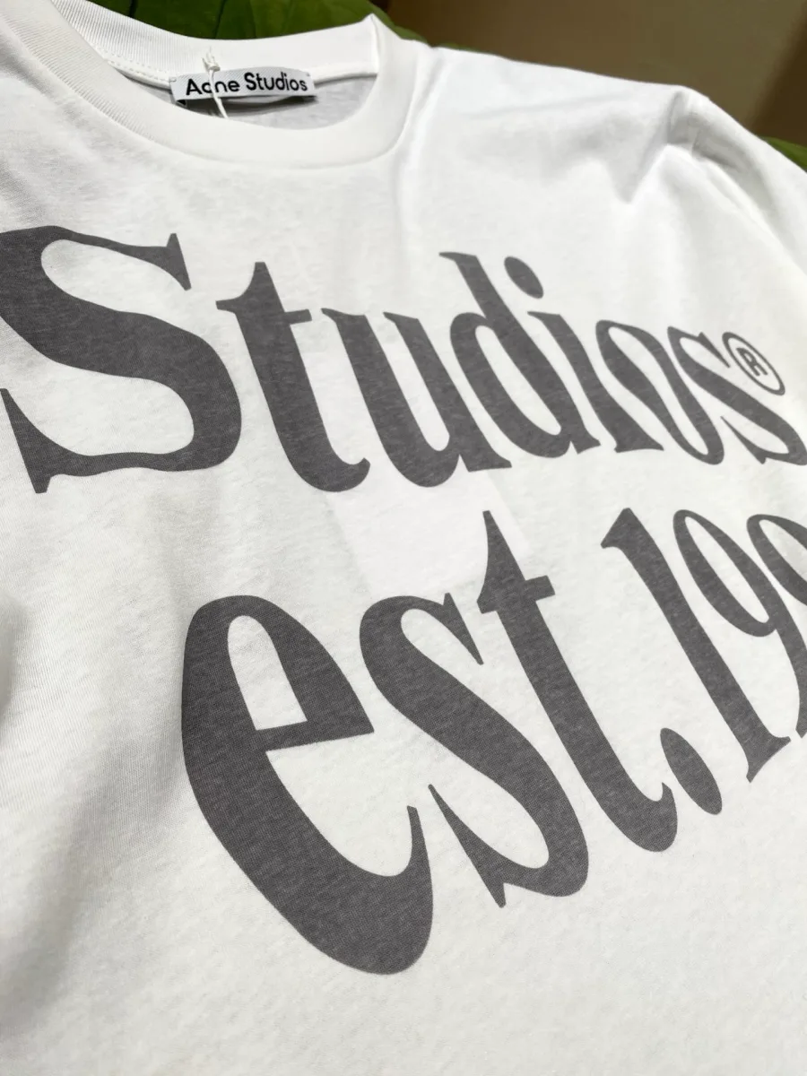 Крупный план надписи Studios est. 1996 и ярлыка на горловине лонгслива